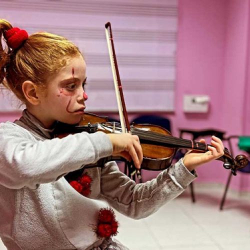 Niña violinista disfrazada de payaso