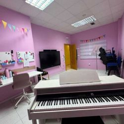 Aula violeta con piano blanco