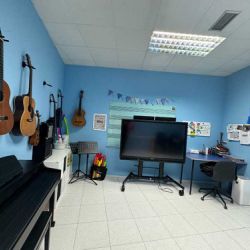 Aula azul con guitarras y piano para clases de música