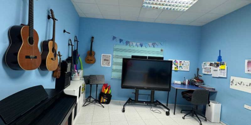 Aula azul con guitarras y piano para clases de música